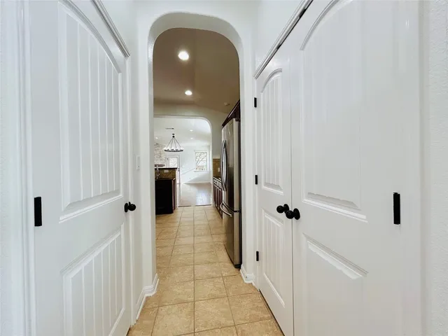 an empty room with wooden floor windows and hallway