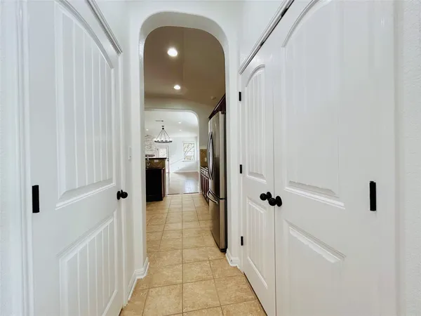 an empty room with wooden floor windows and hallway