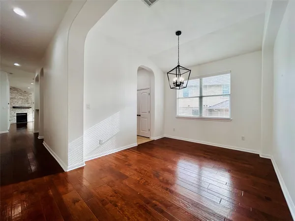 an empty room with wooden floor and cabinet