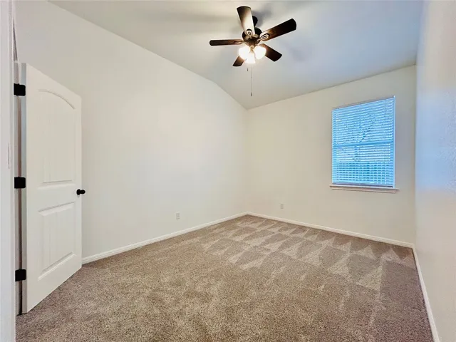 a view of an empty room with a ceiling fan