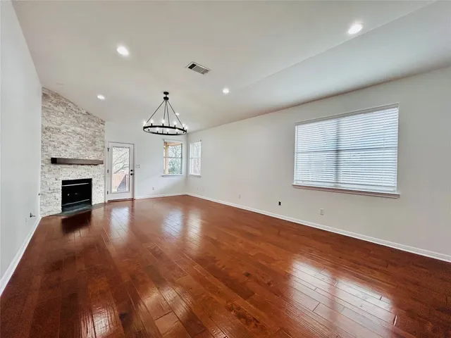 an empty room with windows and fireplace