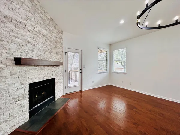 an empty room with windows and fireplace