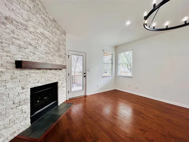an empty room with windows and fireplace