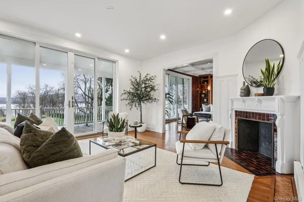 a living room with furniture a fireplace and a floor to ceiling window