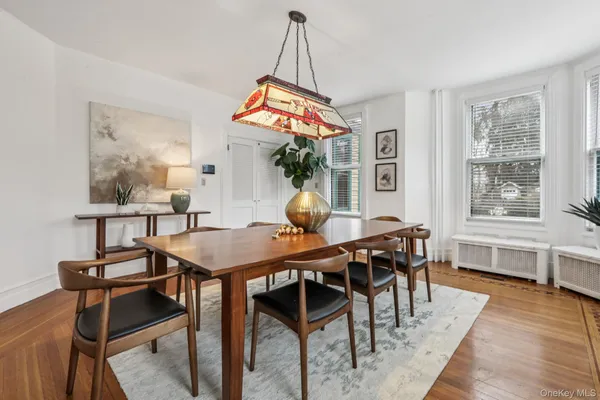 a dining room with furniture a chandelier and wooden floor