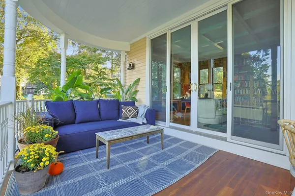a living room with patio furniture and a potted plant
