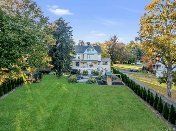 a view of a house with a big yard and large trees