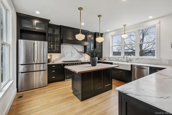 a kitchen with stainless steel appliances granite countertop a sink a stove and a refrigerator