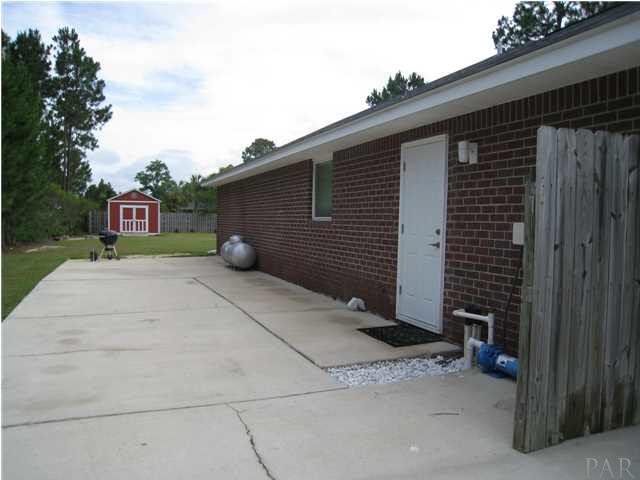 7570 Woodmont Road Navarre, FL 32566 - Photo 25 of 25 Another view of the expansive side drive, side entry door to the garage and the location of the propane hookup for the gas cooktop.