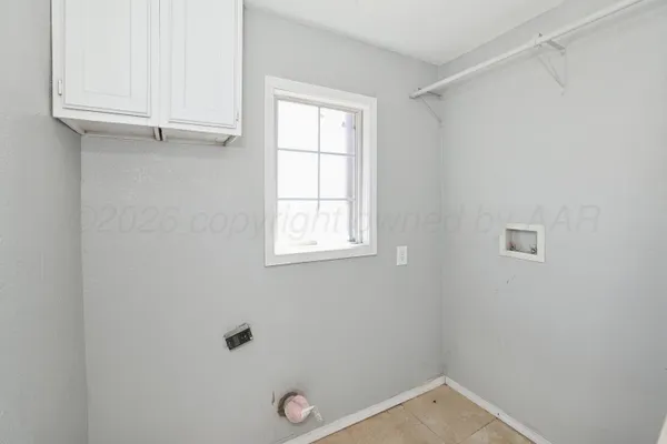 a view of an empty room with window and cabinet