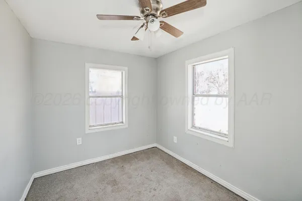 an empty room and a fan in a room