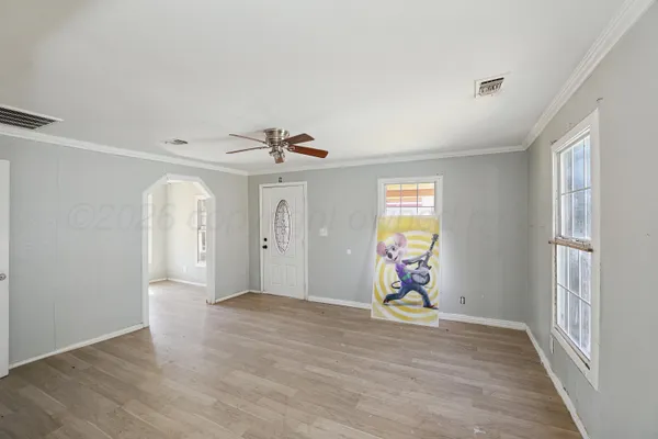 a view of an empty room with window and wooden floor