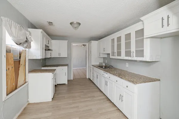 a kitchen with granite countertop a sink stove and refrigerator