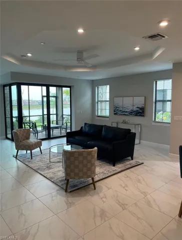 a living room with couches a coffee table and kitchen view with wooden floor