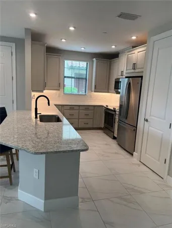 a kitchen with stainless steel appliances granite countertop a refrigerator a sink a stove a microwave and island