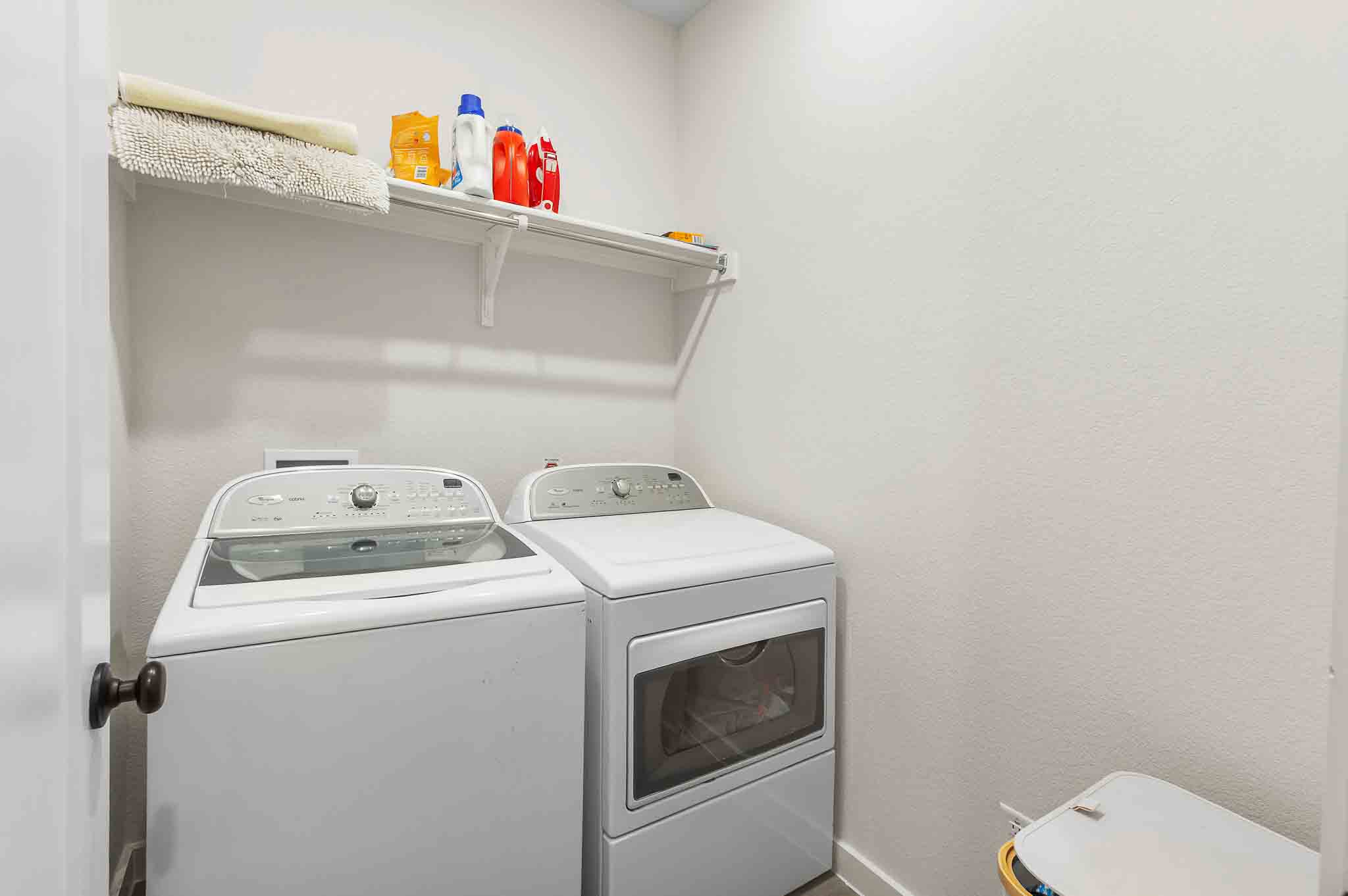 220 Basket Flower Loop Kyle, TX 78640 - Photo 27 of 40 A dedicated utility space with contemporary laundry appliances and convenient upper shelving for storage.