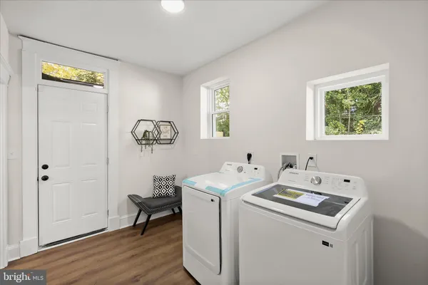 a utility room with wooden floor washer and dryer