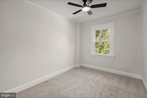 an empty room with closet and a chandelier fan