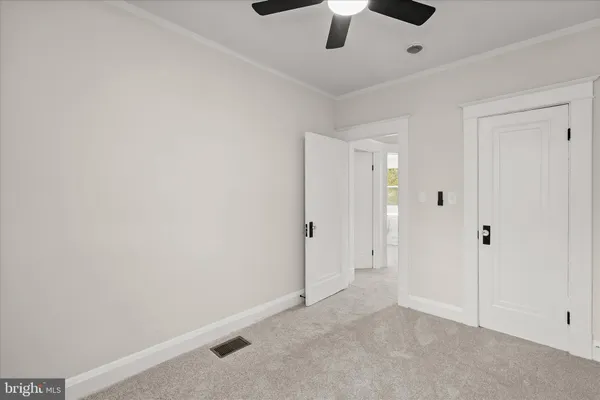 an empty room with a window and a fan