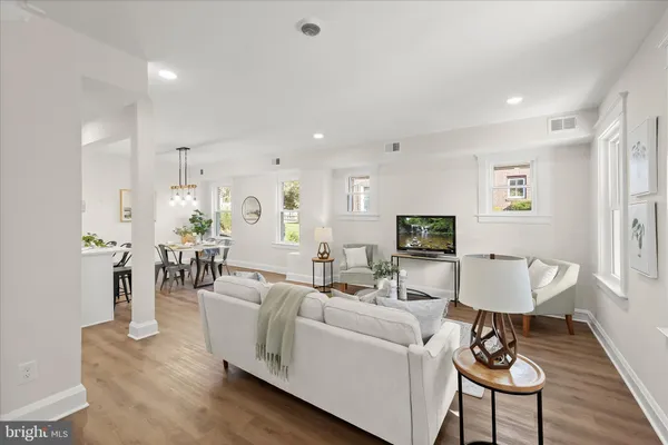 a living room with furniture a wooden floor and a flat screen tv