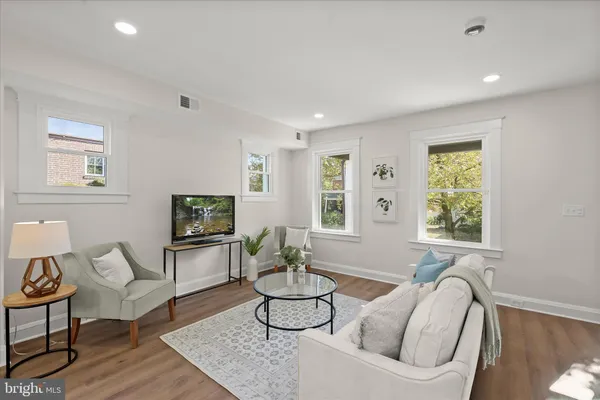 a living room with furniture a window and a flat screen tv