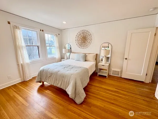 a bed sitting in a spacious bedroom next to a window