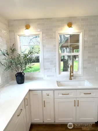 a kitchen with a white cabinets and window