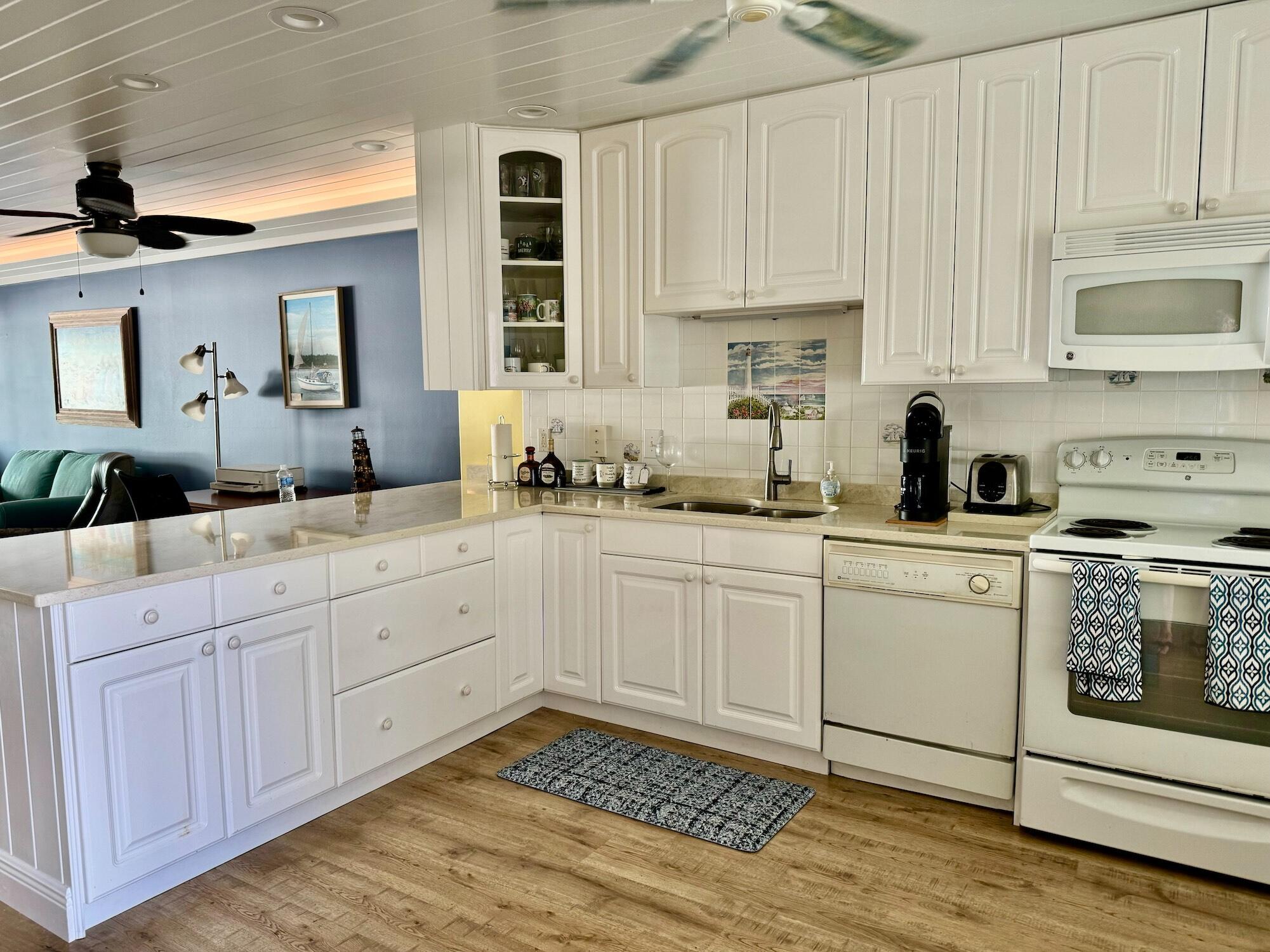 1868 Southwest Palm City Road, Unit 202 Stuart, FL 34994 - Photo 9 of 18 a kitchen with granite countertop white cabinets and white appliances