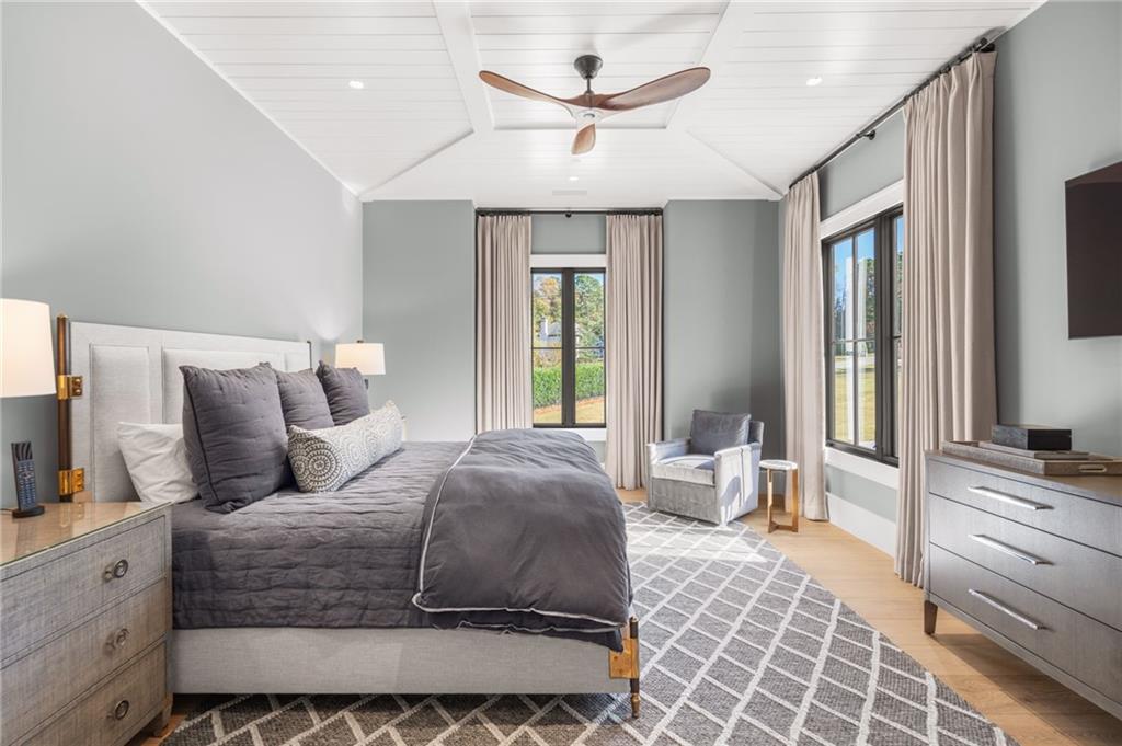 6091 GC Crow Road Flowery Branch, GA 30542 - Photo 37 of 100 a bedroom with a large bed and a chandelier