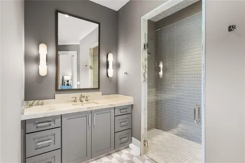 a bathroom with a granite countertop sink a toilet and shower