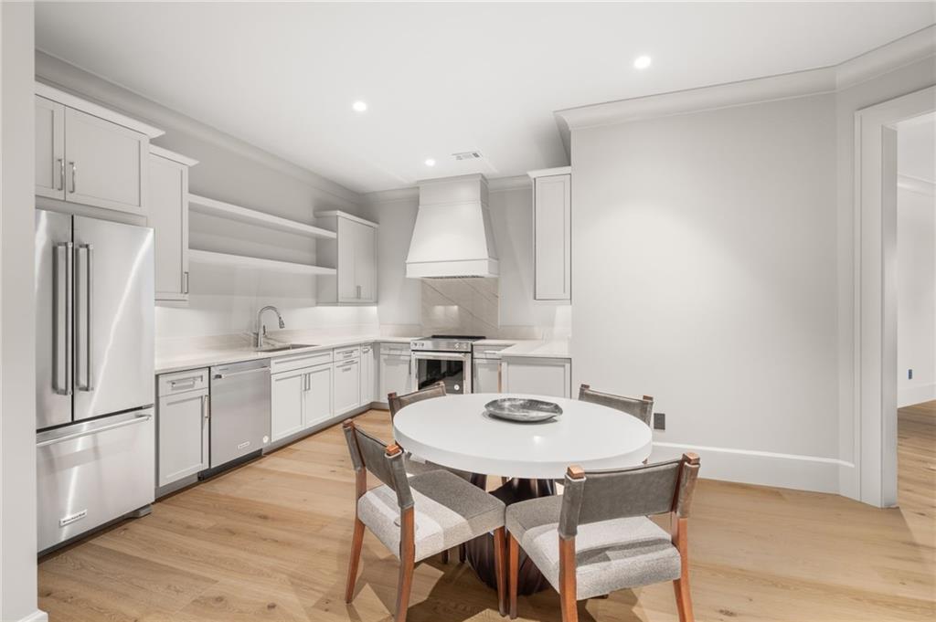 6091 GC Crow Road Flowery Branch, GA 30542 - Photo 71 of 100 a kitchen with stainless steel appliances a dining table chairs and a refrigerator