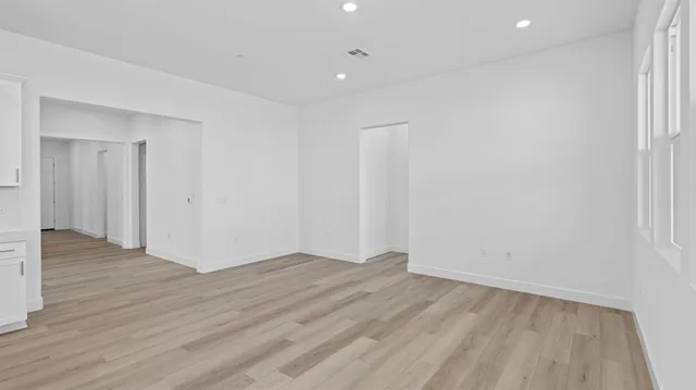 a view of an empty room with wooden floor