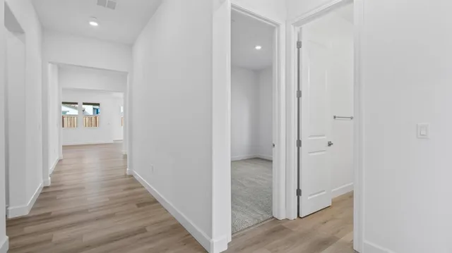 a view of a hallway with wooden floor