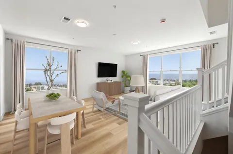 a living room with furniture a flat screen tv and a large window