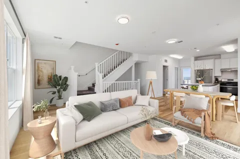 a living room with furniture and a view of kitchen