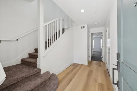 a view of a hallway with wooden floor and entryway