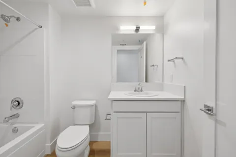 a bathroom with a toilet a sink a mirror and vanity