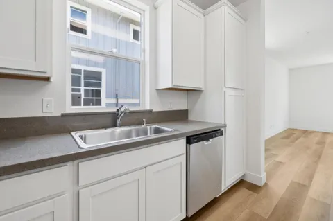 a kitchen with stainless steel appliances granite countertop a sink and a white cabinets