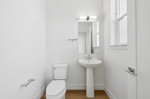 a bathroom with a sink toilet and a mirror