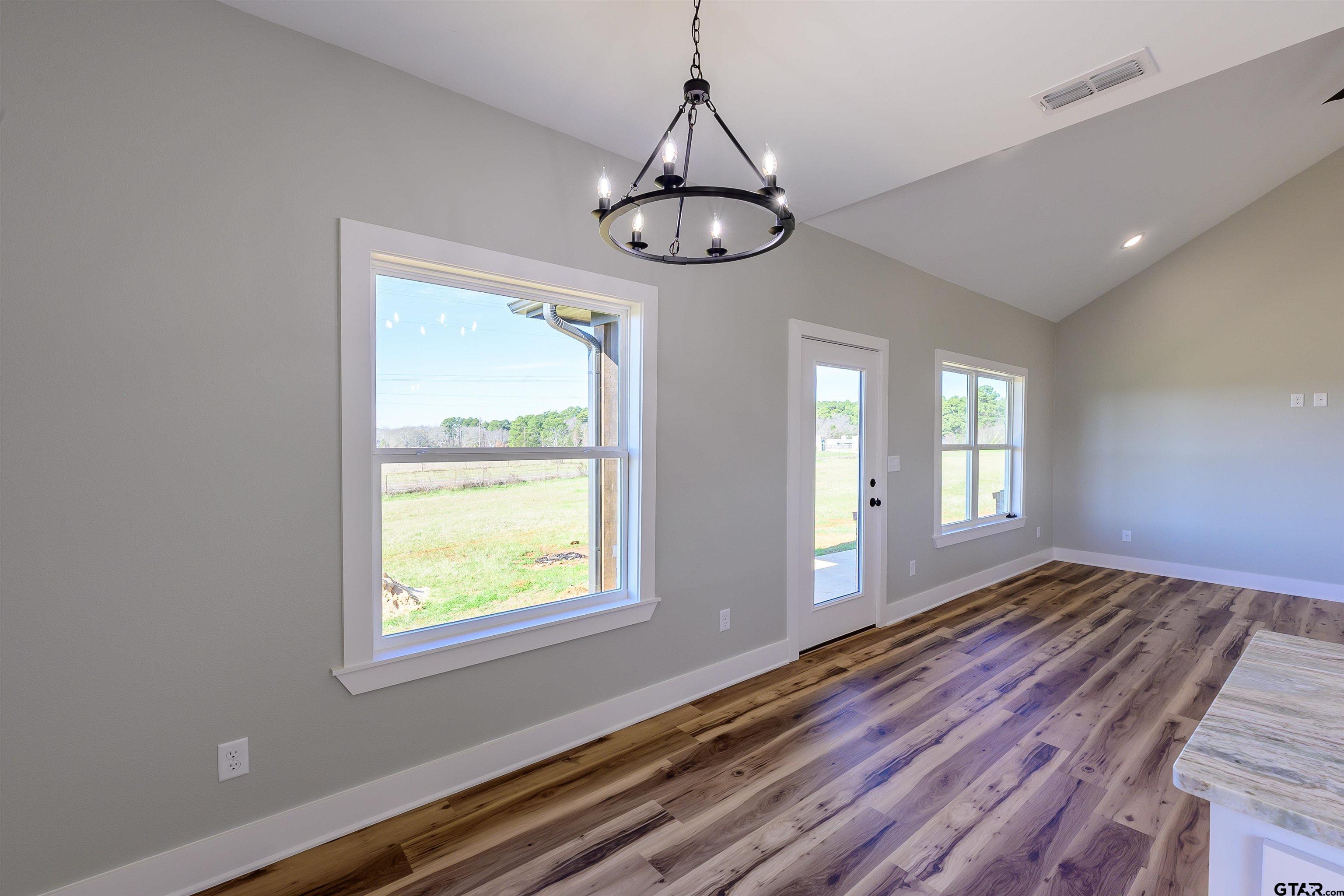 148 Crescent Bullard, TX 75757 - Photo 15 of 40 a view of an empty room with wooden floor and a window