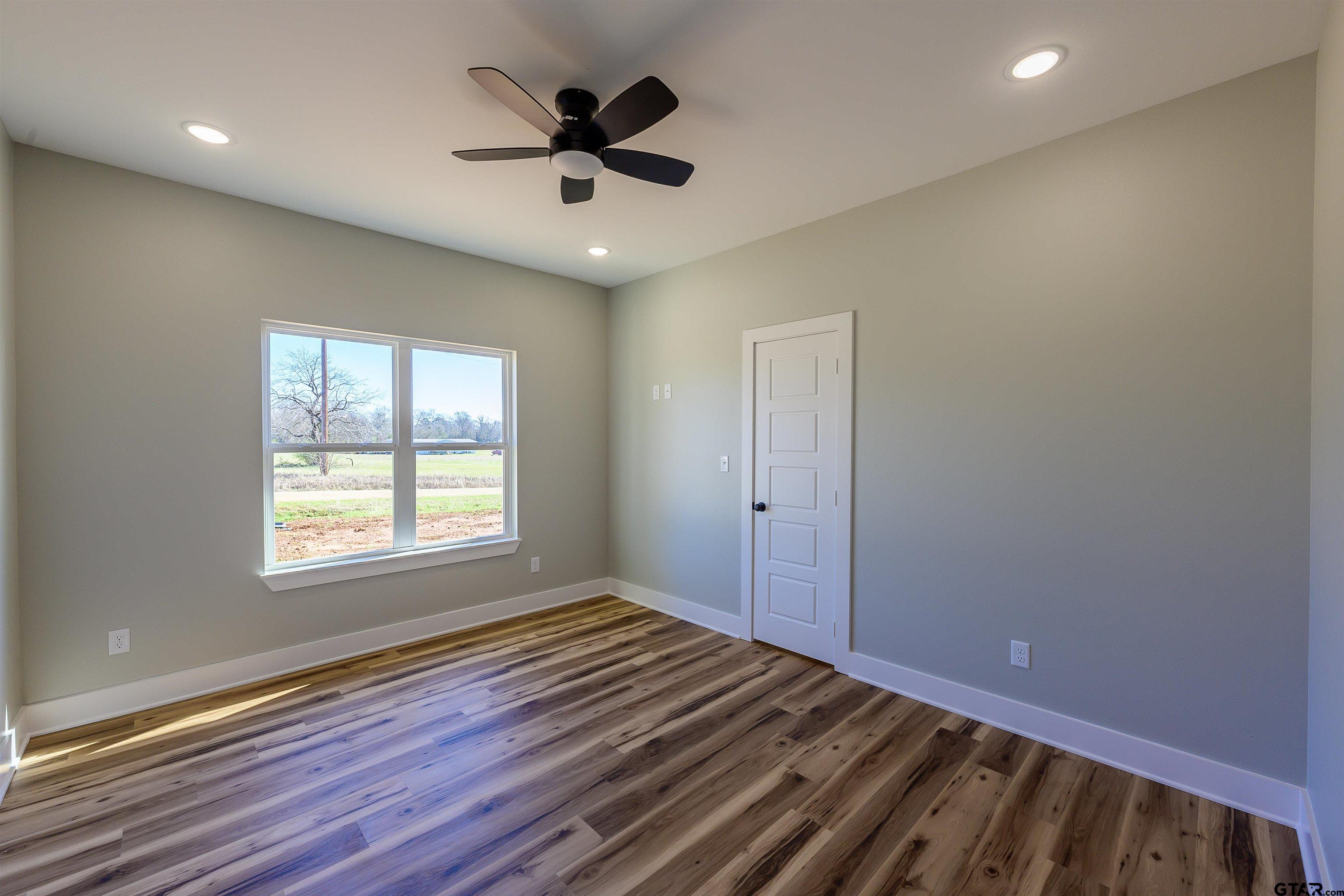148 Crescent Bullard, TX 75757 - Photo 17 of 40 an empty room with wooden floor and windows