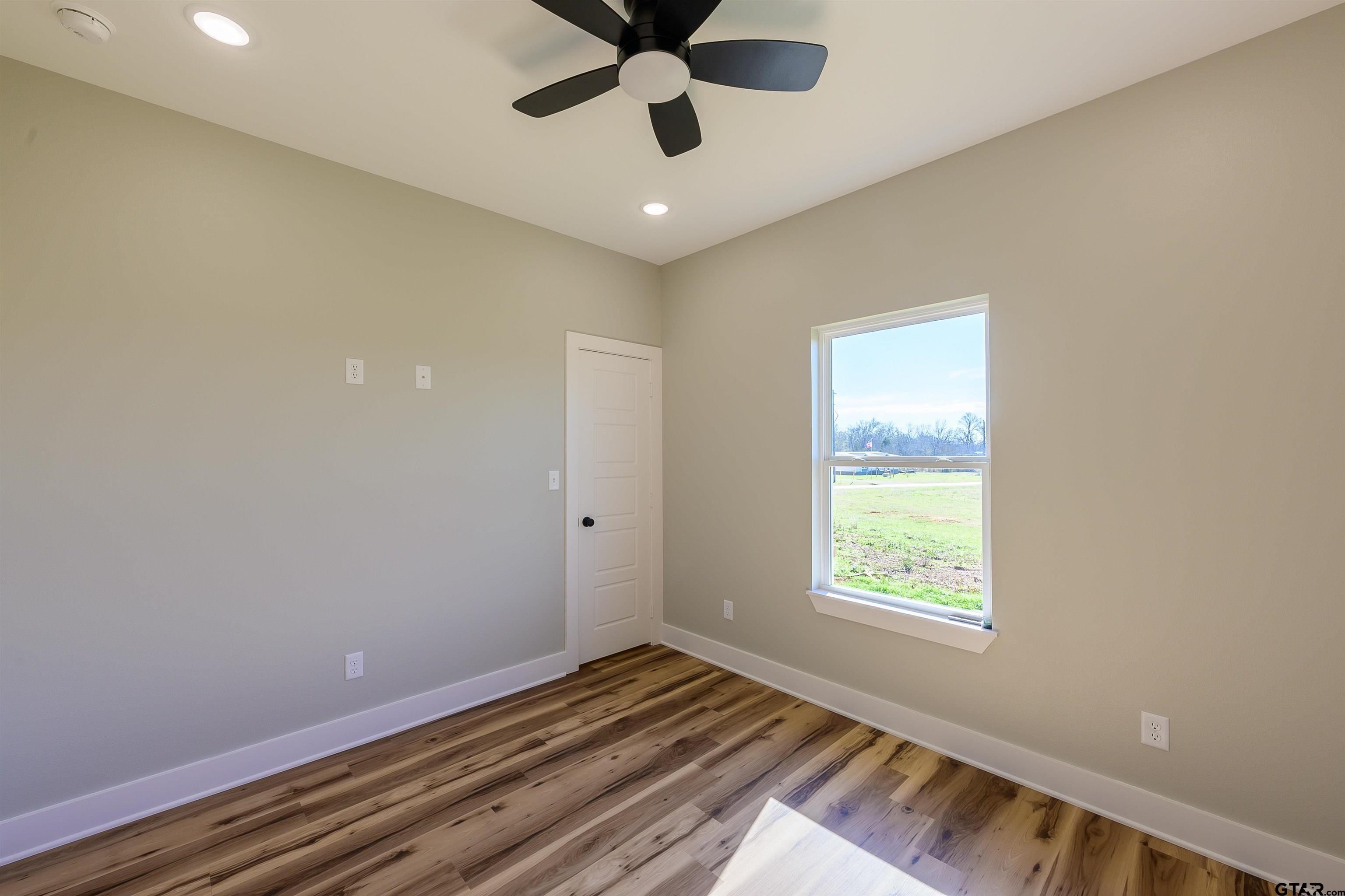 148 Crescent Bullard, TX 75757 - Photo 22 of 40 a view of an empty room and window and a ceiling fan