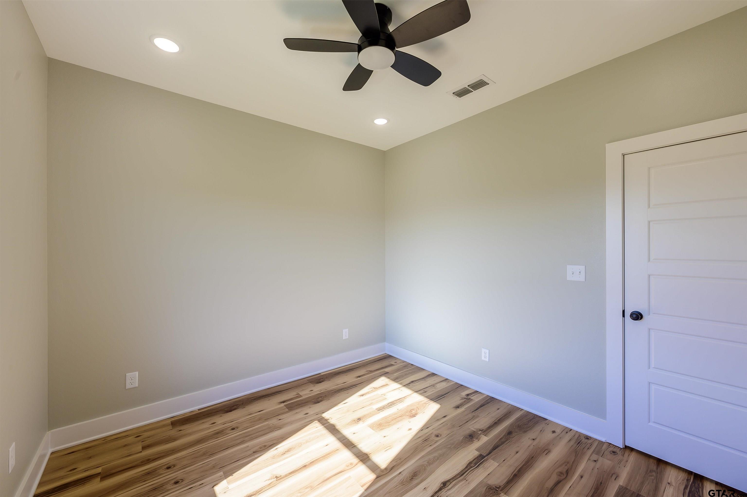 148 Crescent Bullard, TX 75757 - Photo 24 of 40 a view of a big room with wooden floor and a ceiling fan