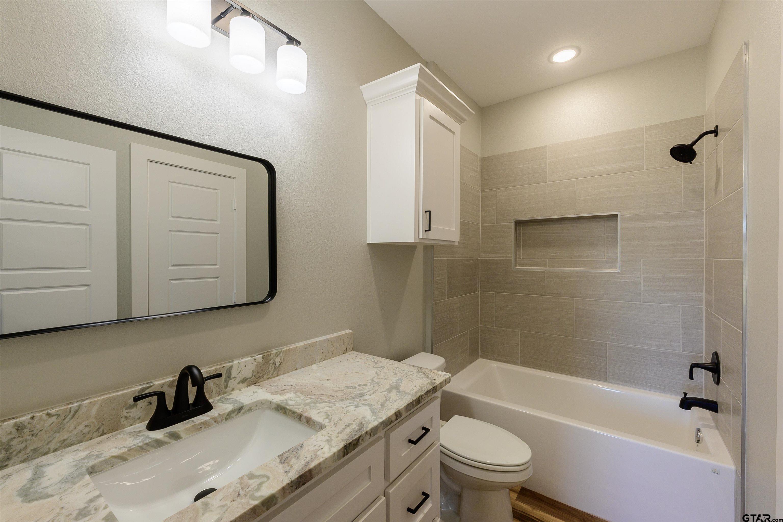 148 Crescent Bullard, TX 75757 - Photo 32 of 40 a bathroom with a granite countertop sink a toilet and shower
