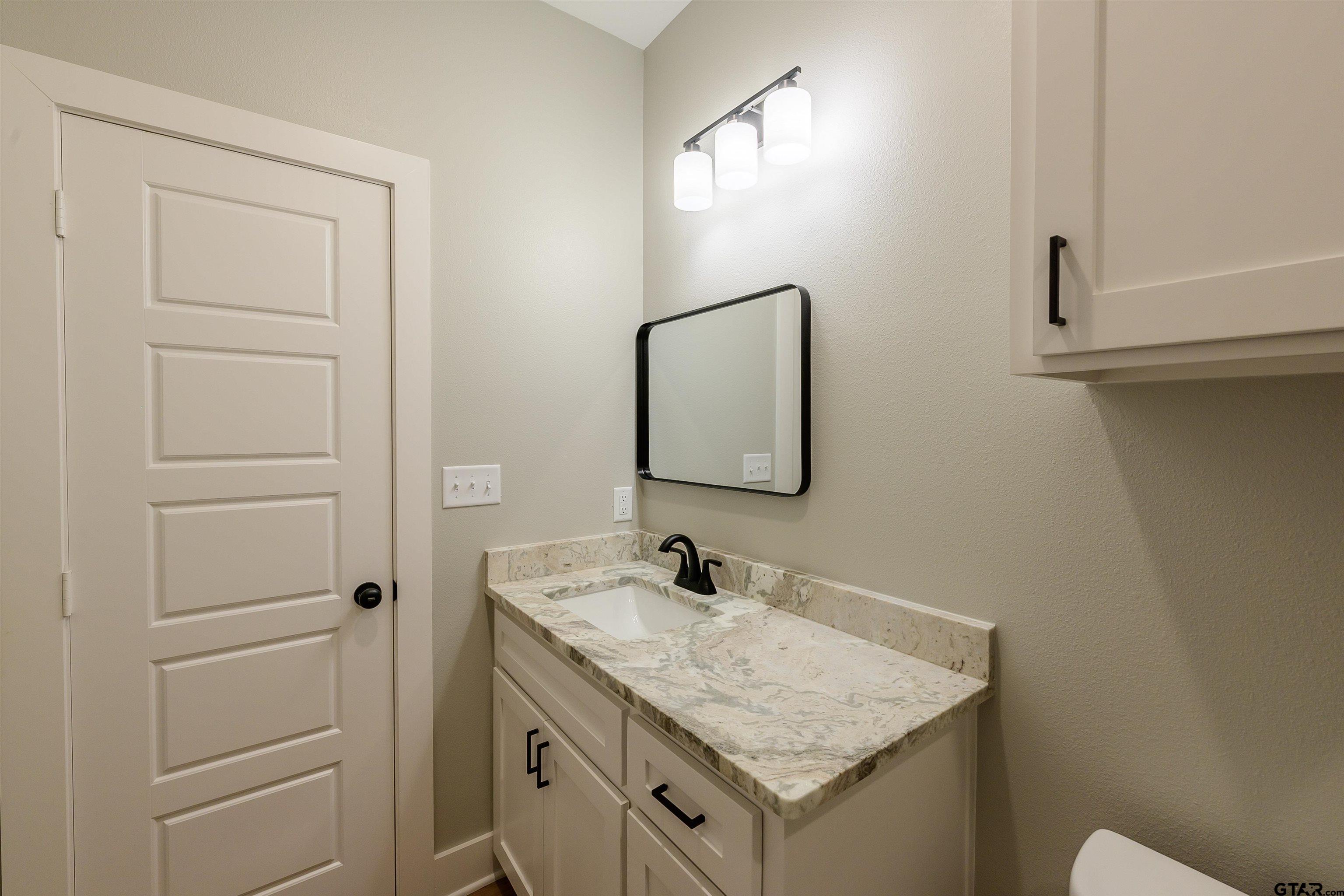 148 Crescent Bullard, TX 75757 - Photo 33 of 40 a bathroom with a granite countertop sink and a mirror