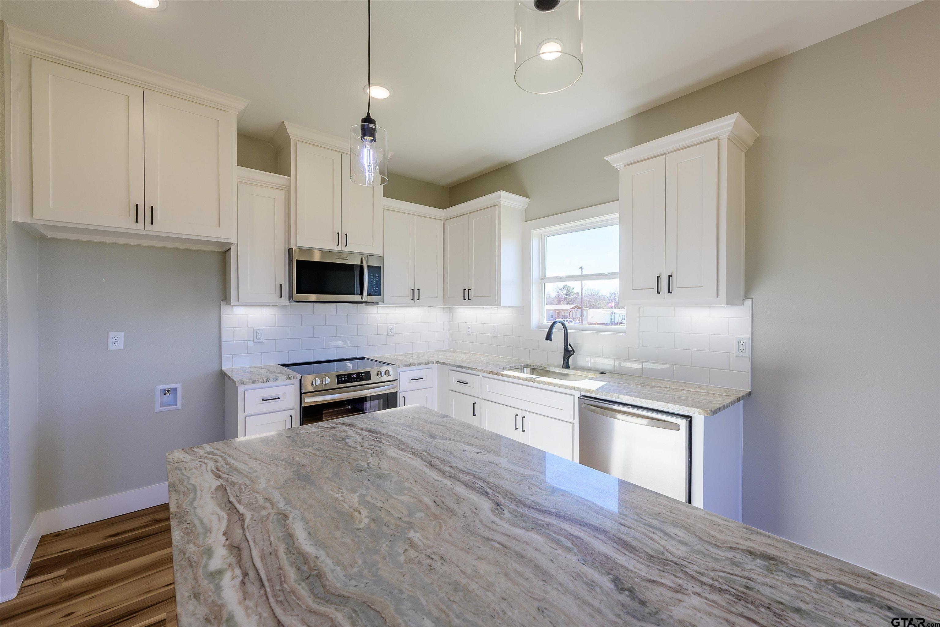 148 Crescent Bullard, TX 75757 - Photo 9 of 40 a kitchen with stainless steel appliances granite countertop a stove and a refrigerator