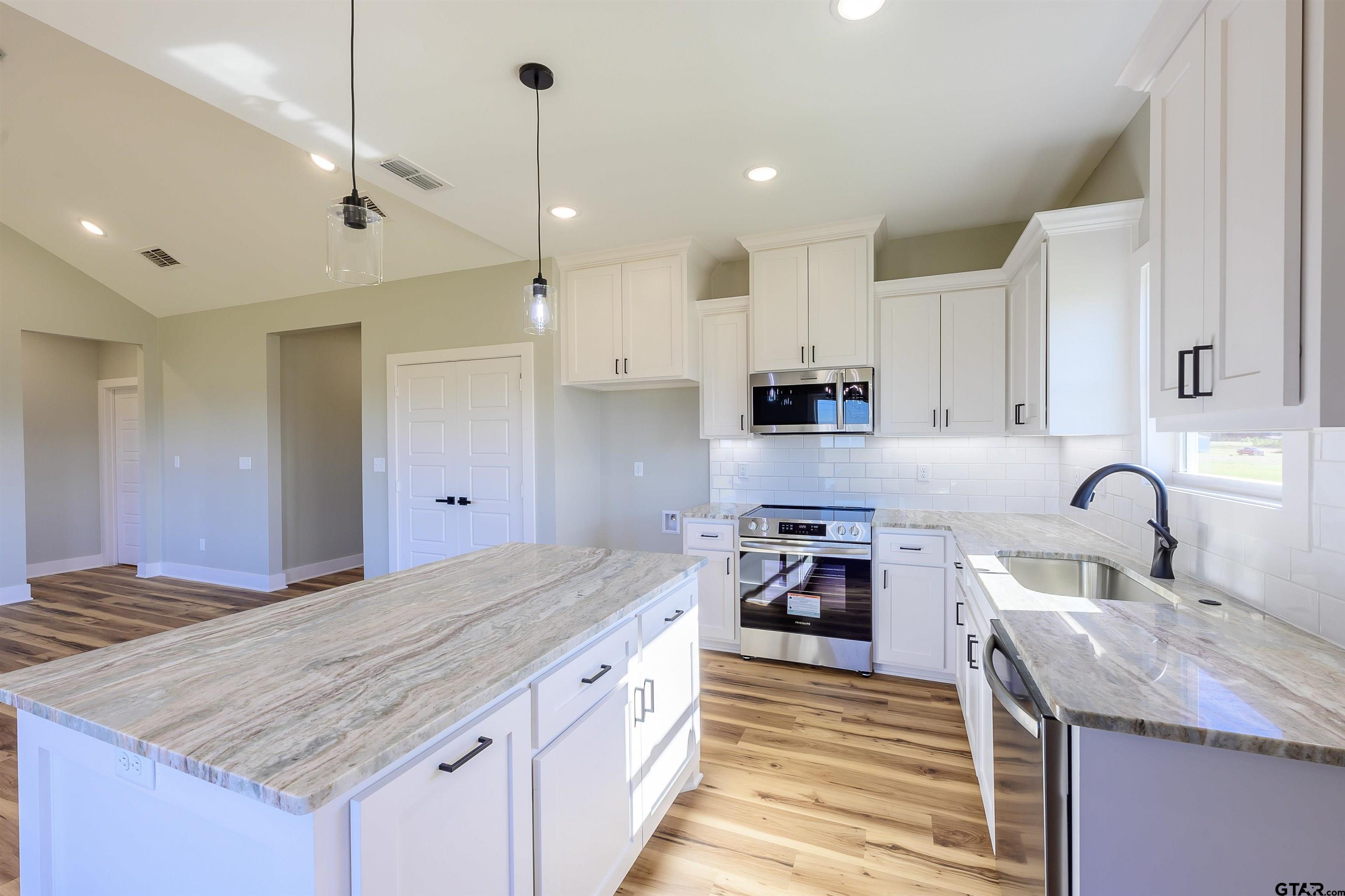 148 Crescent Bullard, TX 75757 - Photo 10 of 40 a kitchen with kitchen island a sink stove and refrigerator