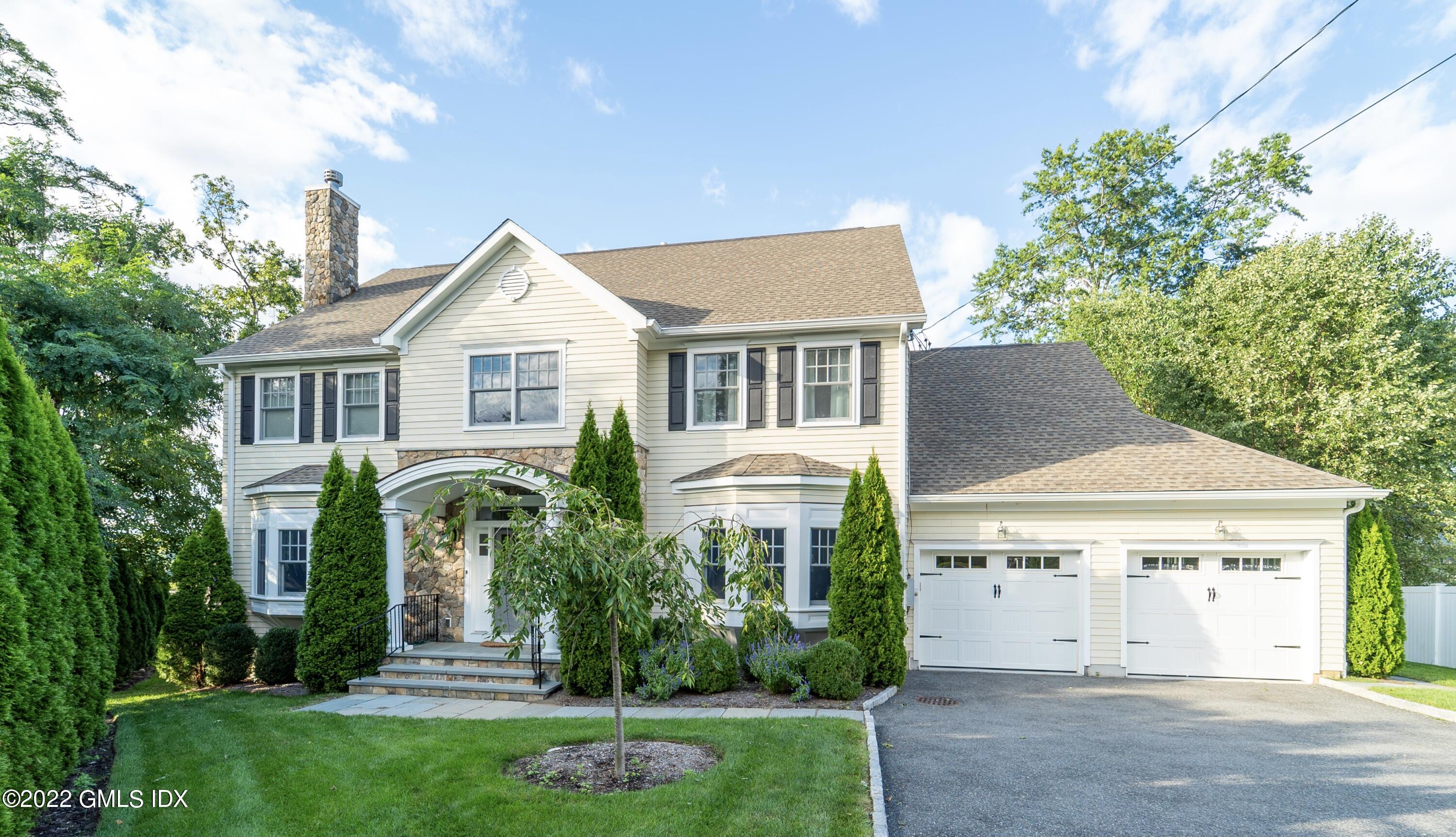 a front view of a house with a garden and plants