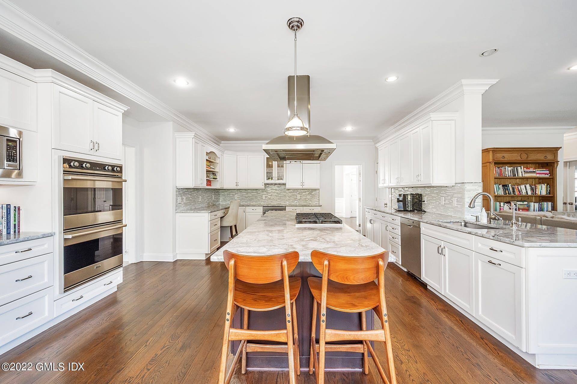 10 Boyd Lane Riverside, CT 06878 - Photo 7 of 30 a kitchen with stainless steel appliances a stove a sink dishwasher and white cabinets with wooden floor