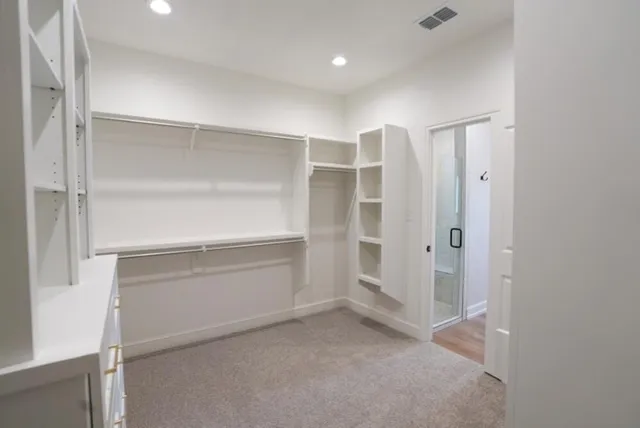 a view of walk in closet with empty racks